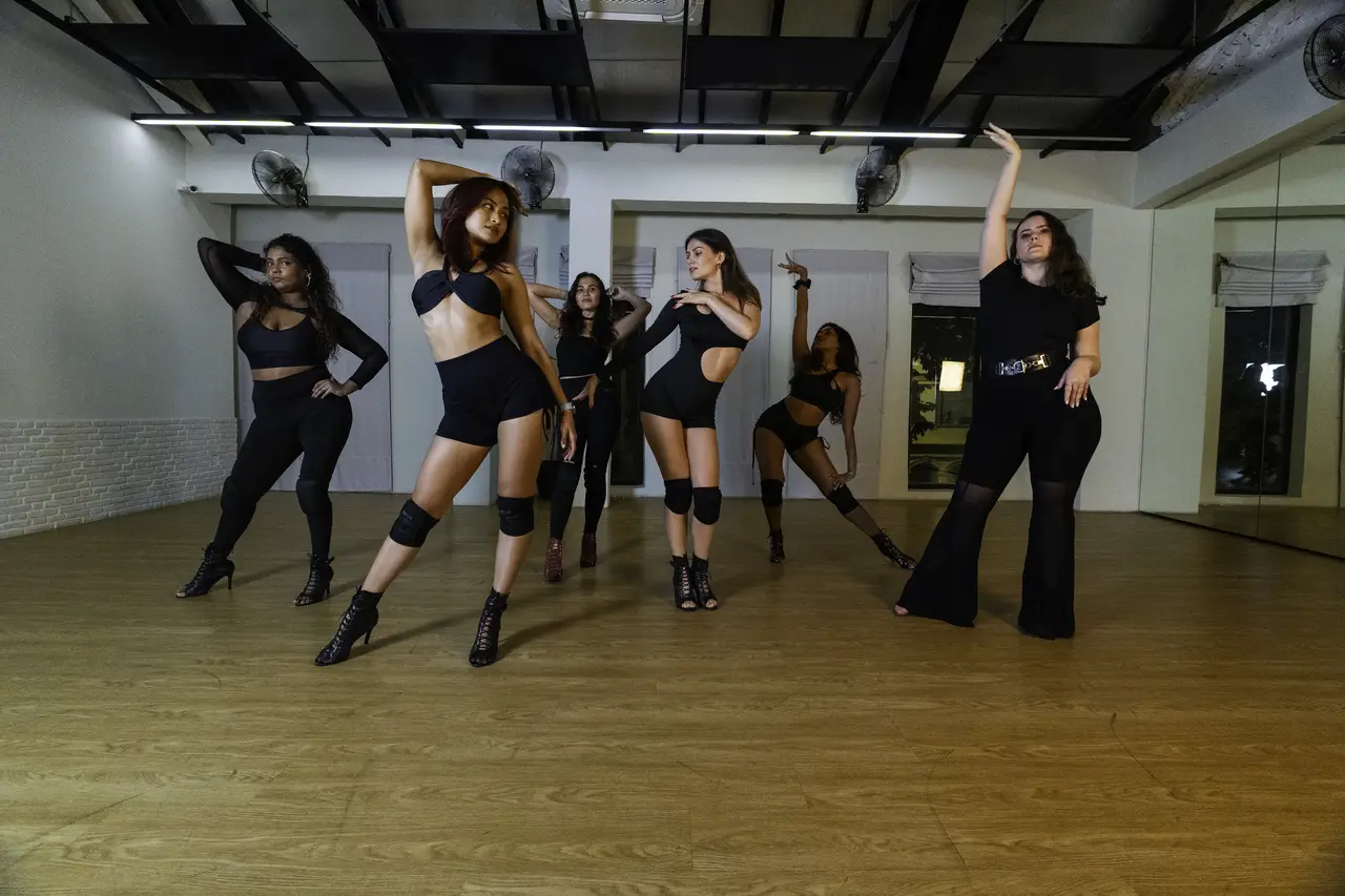 Ksenia Maltseva and Heels Group students posing together in the dance studio